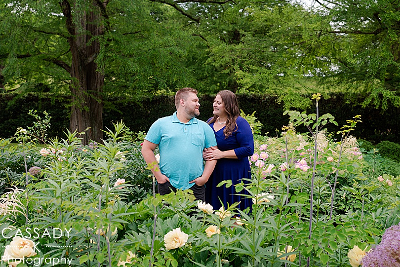 Couple standing in field of flowers looking at each other at Longwood Gardens during their Engagement Photos