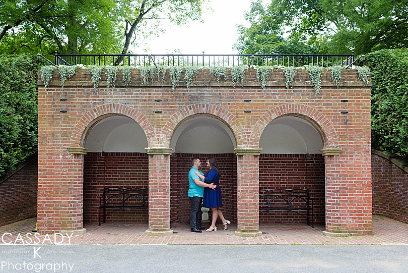 Engaged couple standing in brick alcove at Longwood Gardens Engagement Photos
