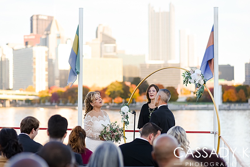Bride and groom standing on boat in fall Gateway Clipper wedding