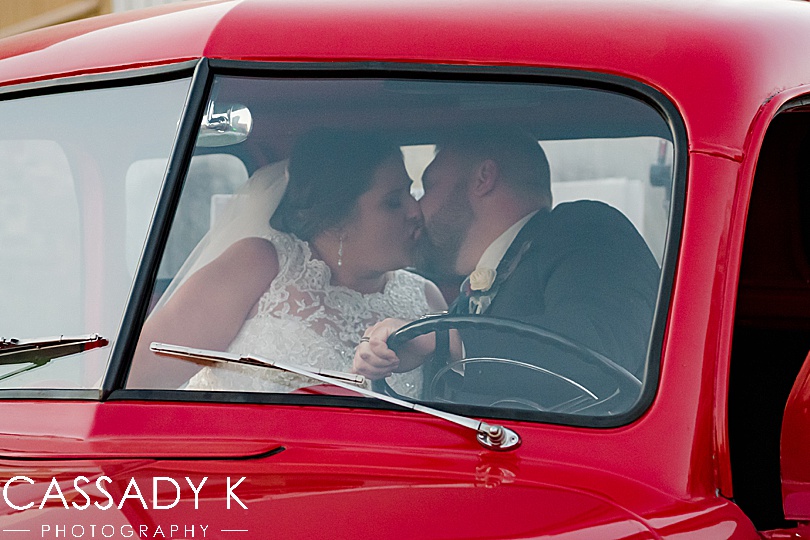 Bride and groom kissing in old red truck at Mount Hope Estate Wedding