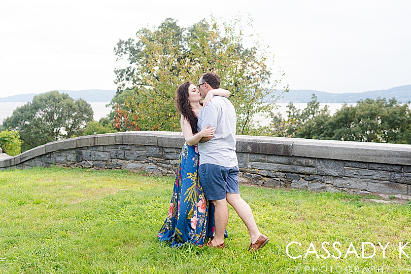 Man and woman kissing in front of Hudson river during Rockwood Hall engagement photos