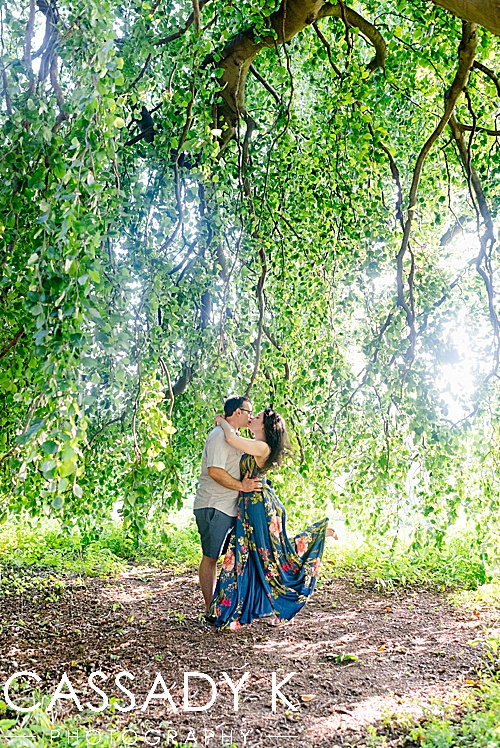 Man and woman kissing under willow tree during Rockwood Hall engagement photos