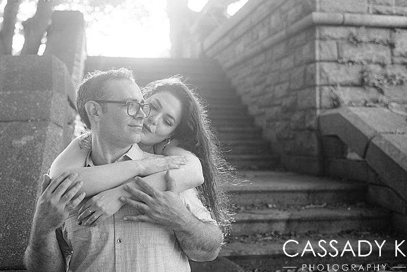 Woman hugging man from behind on stone steps