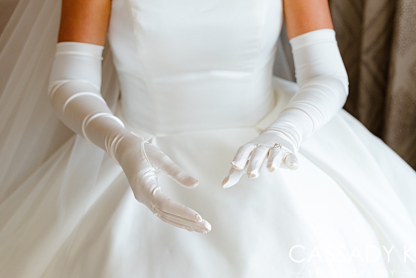 Long white bridal gloves on woman in wedding dress