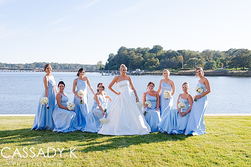 Bridesmaids posing in front of water at Private Estate Tented Wedding