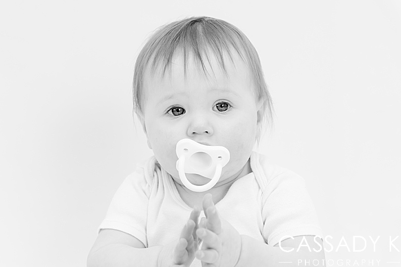 Baby girl with white pacifier in travel portrait studio session