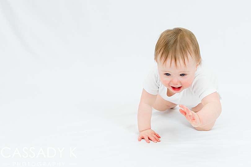 Baby girl crawling in 1 year old portrait session