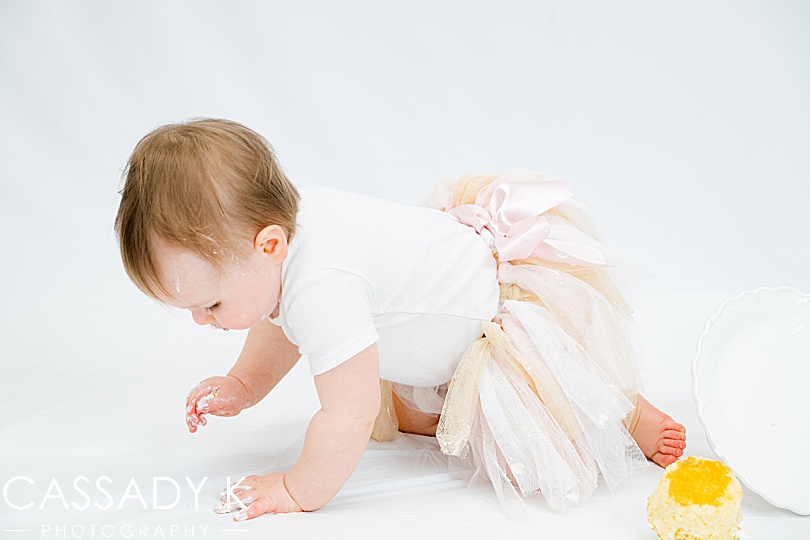 Baby girl crawling against white background in travel portrait studio session
