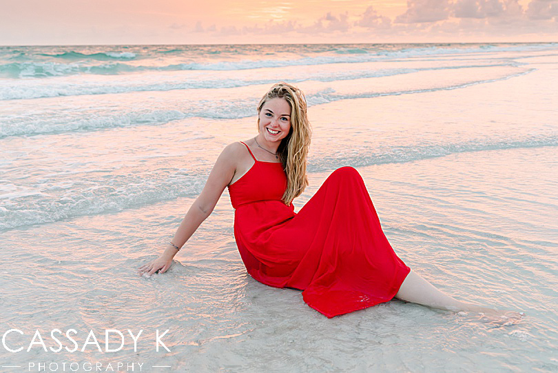 Girl posing in ocean in red dress during Longboat Key Senior Portrait Session