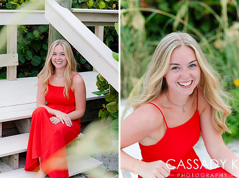 Girl in red dress smiling on wood stairs at beach during Longboat Key Senior Portrait Session