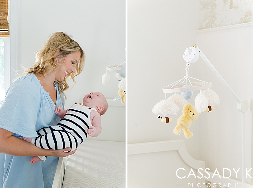 Mom lifting baby boy out of white crib during growing family lifestyle portraits