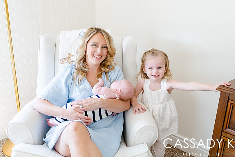 Mom and daughter smiling with newborn baby boy during Growing Family Lifestyle Session