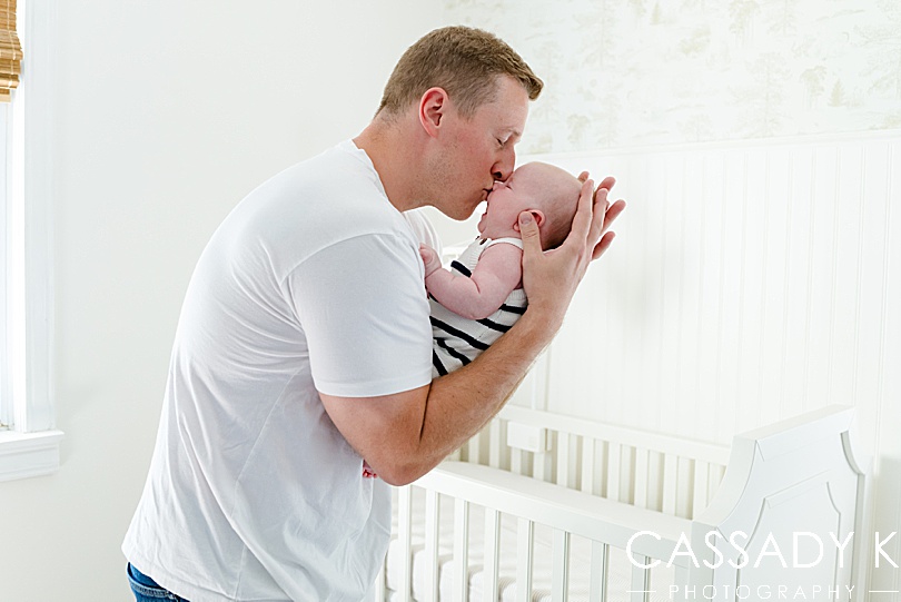 Dad holding and kissing baby boy during Growing Family Lifestyle Sesssion