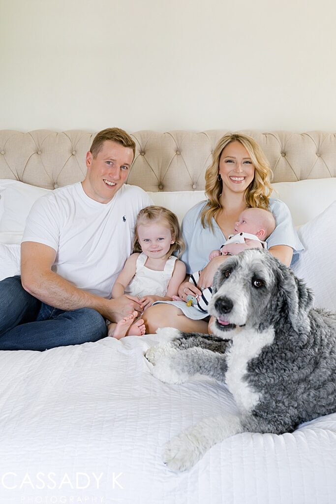 Family sitting on bed with newborn baby brother during Growing Family Lifestyle Session