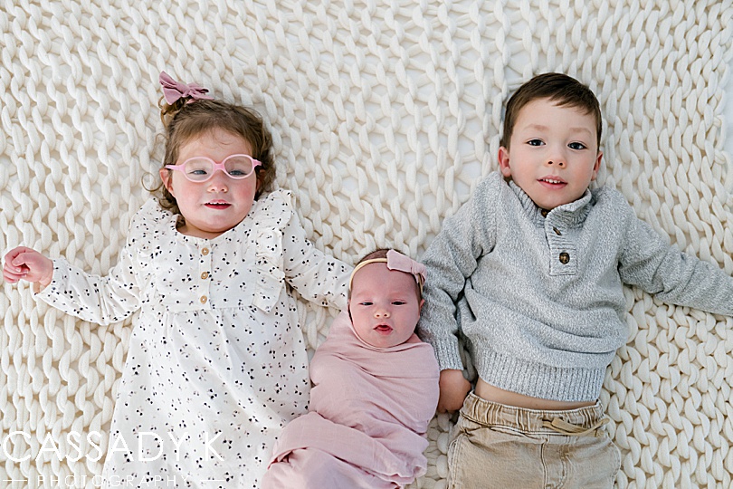 Older brother and sister lay with newborn baby sister in northern NJ 