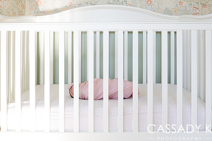 Baby girl lays in her crib during a newborn photography session in NJ