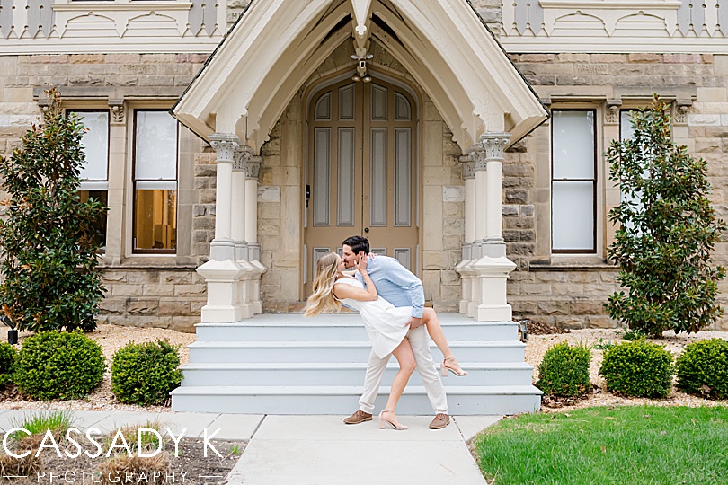 Husband dips his wife in front of the Ohio House and its architecture during Cherry Blossoms in Fairmount Park, Philadelphia