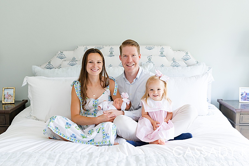 First family portrait in the parents' bed with a newborn baby girl and older, toddler sister in Doylestown, PA